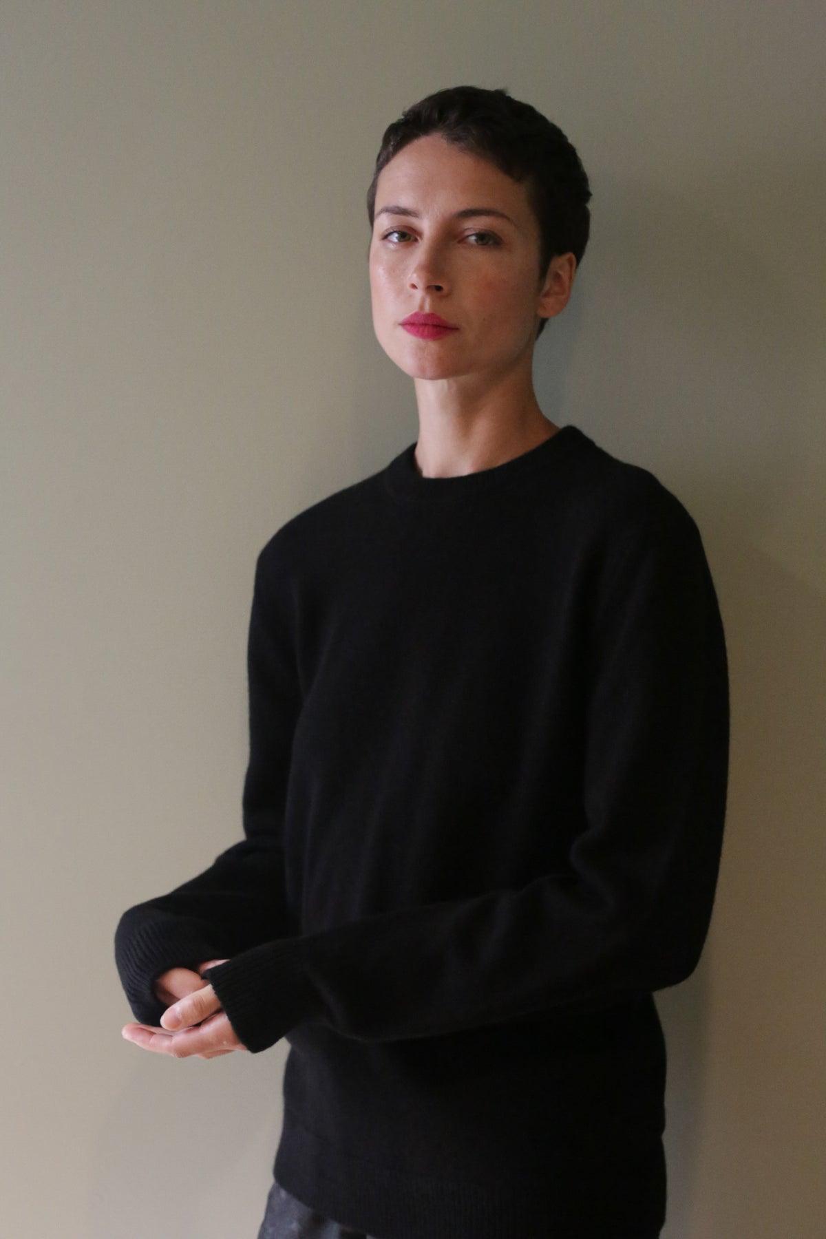 A person with short hair wearing a black Unisex Heavyweight Cashmere Crewneck.