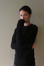 Load image into Gallery viewer, A person wearing a black Unisex Heavyweight Cashmere Crewneck with their hand resting near their chin.