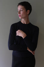 Load image into Gallery viewer, A person wearing a black Cropped Silk Crewneck with a hand-linked silk construction, long sleeves, and a cropped hem.