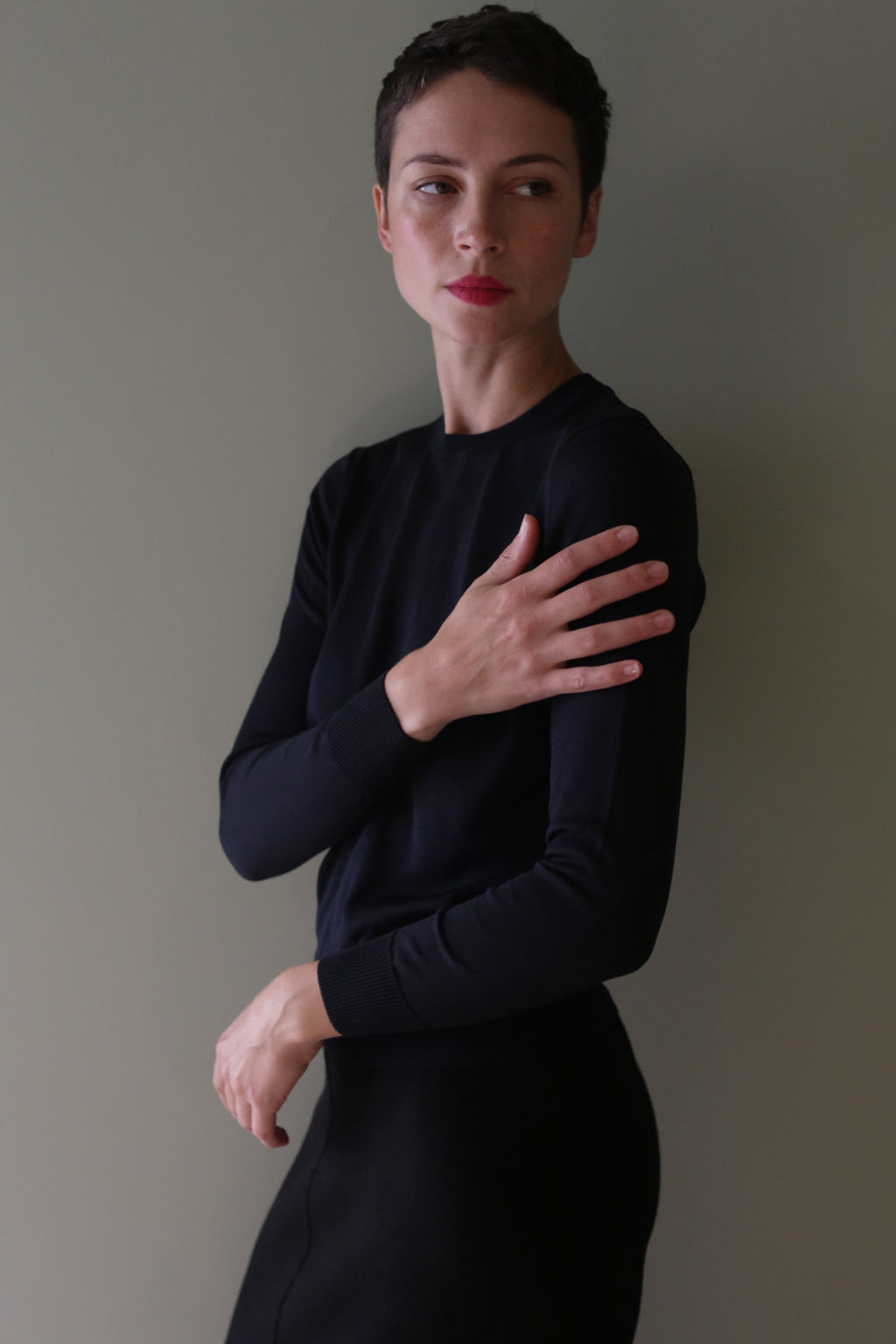 A person wearing a long-sleeved, dark blue Washable Silk Crewneck in Blue Black made in Japan.