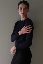 Load image into Gallery viewer, A person wearing a blue black Cropped Silk Crewneck, a dark-colored, long-sleeved silk crewneck sweater.
