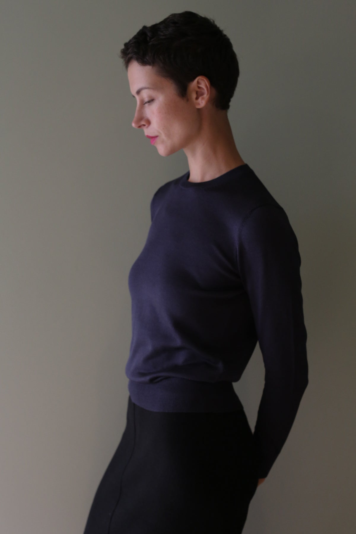 A person in profile wearing a cropped Washable Silk Crewneck | Navy.