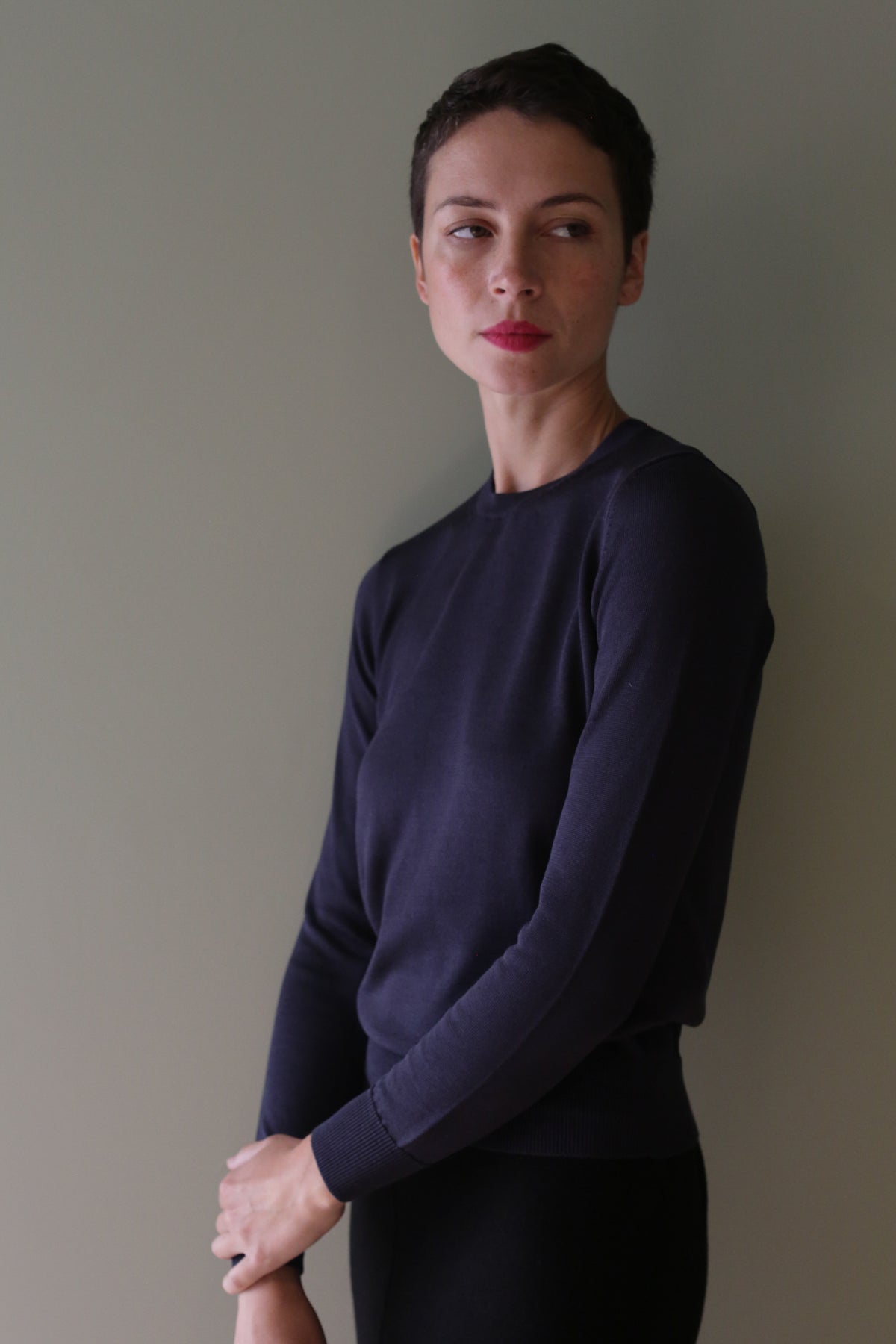 A person with short hair wearing a navy blue cropped Washable Silk Crewneck.