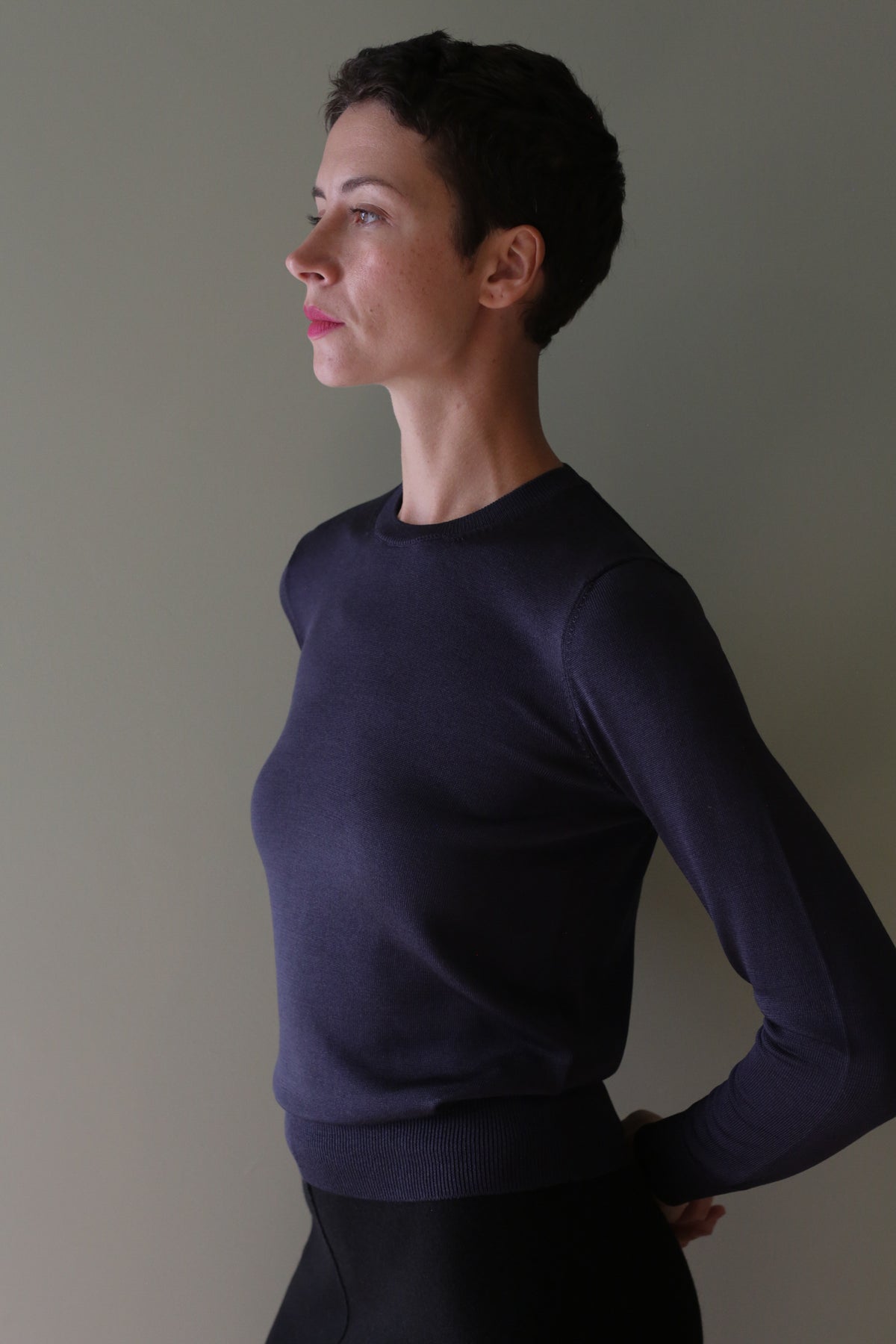Side profile of a person wearing a navy blue Washable Silk Crewneck.