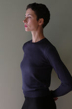 Load image into Gallery viewer, A person in profile wearing a navy blue Cropped Silk Crewneck sweater with long sleeves.