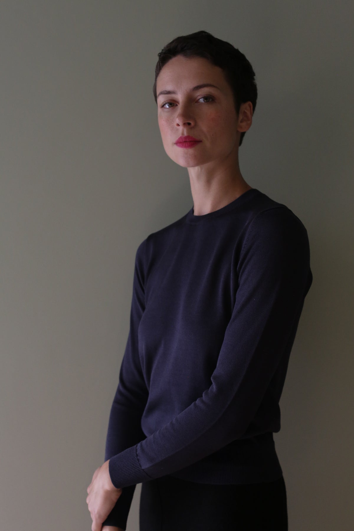 A person with short hair wearing a navy Washable Silk Crewneck.