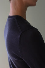 Load image into Gallery viewer, Close-up of a person wearing a navy Cropped Silk Crewneck with stitched shoulder detailing.