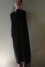 Load image into Gallery viewer, A person wearing a long-sleeved, floor-length black Cashmere Sweater Dress.
