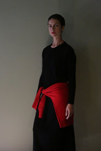 Load image into Gallery viewer, A person wears a black Cashmere Sweater Dress with a red sweater tied around their waist.