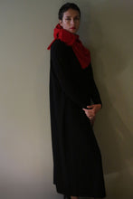 Load image into Gallery viewer, A person wearing a long black Cashmere Sweater Dress and a bright red scarf around their neck.