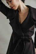 A person wearing a Malvern | Brown long cashmere wrap coat with a tie waist.