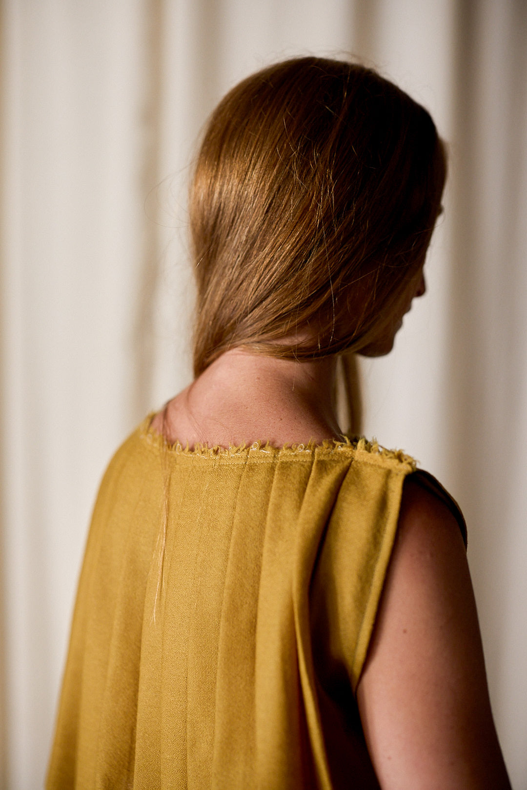 model wearing column dress in gold
