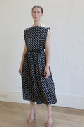 A woman in a Magnolia Dress | B/W Polkadot with an elegant open back.