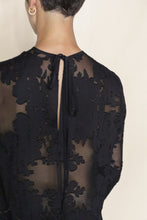 Load image into Gallery viewer, A person with short hair and a gold hoop earring is seen from behind wearing the Crewneck Dress | Silk Uragiri Black by Lan Jaenicke, a handmade San Francisco design with floral embroidery and a keyhole back tied with ribbon.