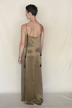 Load image into Gallery viewer, A person with short hair, wearing the handmade Silk Cord Dress | Gold with thin black straps and tassels, stands facing away from the camera against a plain light background. Made in San Francisco.
