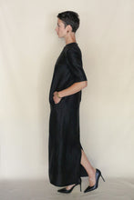 Load image into Gallery viewer, A person with short hair, in profile against a plain light background, wears the Xiang Yun Silk Earth Mark Crewneck Dress with short sleeves and black high heels.