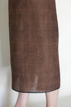 Load image into Gallery viewer, A close-up of a person wearing the Futo Dress Reversible in Xiang Yun Silk Endless Bloom, featuring a subtle jacquard pattern and simple hem, with the calf-length skirt and lower leg highlighted against a light background.