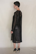 Load image into Gallery viewer, A person with short dark hair stands sideways, looking left, wearing a sheer handmade Crewneck Dress | Linen Leno Black and black high heels against a plain light background.