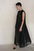 Load image into Gallery viewer, A person with short hair stands sideways in the Shoulder Pleat Dress | Linen Leno Black, handmade in San Francisco from luxurious linen leno, paired with black heels against a plain light background.