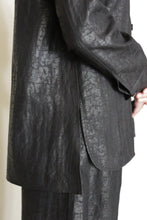 Load image into Gallery viewer, A close-up of a person in a textured black suit, showcasing the Studio Shirt | Xiang Yun Silk Earth Mark. The model stands sideways with hands clasped, displaying only the torso and upper legs.