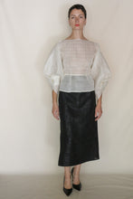 Load image into Gallery viewer, A woman stands against a plain background wearing the Origami | Silk Mesh top with wide sleeves, a black calf-length skirt, and black pointed-toe heels.