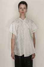 Load image into Gallery viewer, A person with short brown hair stands facing forward, wearing the handmade Qipao Vest Hidden Peony Undyed and dark pants, against a plain beige background.