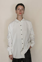 Load image into Gallery viewer, A person with short dark hair wears the Men's Shirt | Cotton Omizarashi Undyed, paired with dark pants. They stand against a plain, light background with one hand in their pocket, evoking handmade San Francisco style.