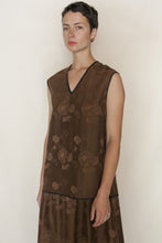 Load image into Gallery viewer, A person with short dark hair wears the V Neck Tank Reversible | Xiang Yun Silk Lingering Fragrance dress, featuring a subtle floral pattern and black trim, standing against a plain light background.