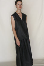 Load image into Gallery viewer, A person with short hair wears the V Neck Tank Reversible in Xiang Yun Silk Faux Bois, a sleeveless, loose-fitting black dress, standing against a plain light background.