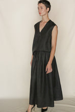 Load image into Gallery viewer, A woman with short hair wears the A Line Skirt in Xiang Yun Silk Faux Bois, styled with black heels and standing against an off-white background.
