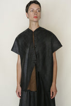 Load image into Gallery viewer, A woman with short hair wears the loose-fitting, reversible Qipao Vest Reversible | Xiang Yun Silk Faux Bois in black over a brown top, standing against a plain light background.