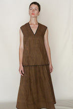 Load image into Gallery viewer, Wearing a sleeveless brown V-neck top and the A Line Skirt | Xiang Yun Silk Faux Bois, a person stands against a light background, gazing slightly to the side with a neutral expression.