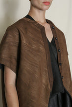 Load image into Gallery viewer, A person wears the Qipao Vest Reversible | Xiang Yun Silk Faux Bois, styled loose over a dark inner top, shown from the shoulders down against a plain light background.