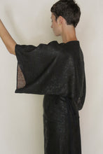 Load image into Gallery viewer, A person with short hair wears the Kimono Top Reversible | Xiang Yun Silk Endless Bloom, a kimono-style piece with wide sleeves, standing in profile against a plain background. The luxurious reversible silk adds texture and elegance.