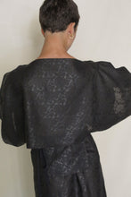 Load image into Gallery viewer, A person with short dark hair wears the Kimono Top Reversible | Xiang Yun Silk Endless Bloom, shown from the back against a plain light background. A gold hoop earring highlights the elegance of this reversible silk kimono top.
