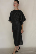 Load image into Gallery viewer, A woman with short dark hair and a neutral expression poses against a plain background wearing the Kimono Top Reversible in Xiang Yun Silk Endless Bloom, styled with black heels and wide short sleeves, one arm relaxed at her side.