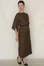 Load image into Gallery viewer, A person wears the Kimono Top Reversible | Xiang Yun Silk Endless Bloom in brown, styled loosely with short sleeves and a black belt, paired with black pointed-toe heels, standing against a plain light background and looking to the side.