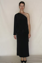 Load image into Gallery viewer, A person with short hair and a neutral expression stands against a plain light background wearing the Eurie Skirt in 2 Ply Silk Crepe Black paired with black heels.
