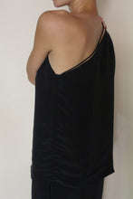 Load image into Gallery viewer, A person with short hair is seen from behind, wearing the Eurie Blouse in 2 Ply Silk Crepe Black—an asymmetrical, one-shoulder design—set against a plain light background.