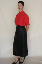 Load image into Gallery viewer, Against a plain backdrop, a person with short dark hair wears the Work Shirt Crop in Organic Typewriter Cotton Vermillion, paired with a long black skirt and black high-heeled shoes—showcasing handmade San Francisco craftsmanship.