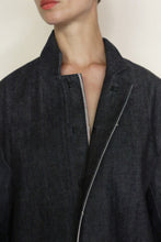 Load image into Gallery viewer, A person wears the Painter's Jacket | Japanese Selvedge Denim with an open collar and no fastened buttons, revealing part of their neck and jawline against a plain background.