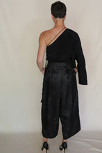 Load image into Gallery viewer, Seen from behind, a person with short hair wears a black asymmetrical outfit featuring the Samurai Pants | Xiang Yun Silk Lingering Fragrance and black high heels, standing against a plain light background.