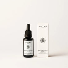 Load image into Gallery viewer, A bottle of Phyto Radiance Day Oil, enriched with Prickly Pear seed oil, is showcased beside its packaging. The sleek black bottle with a dropper cap is adorned with a geometric floral pattern against a pristine, light backdrop, highlighting its natural elegance.