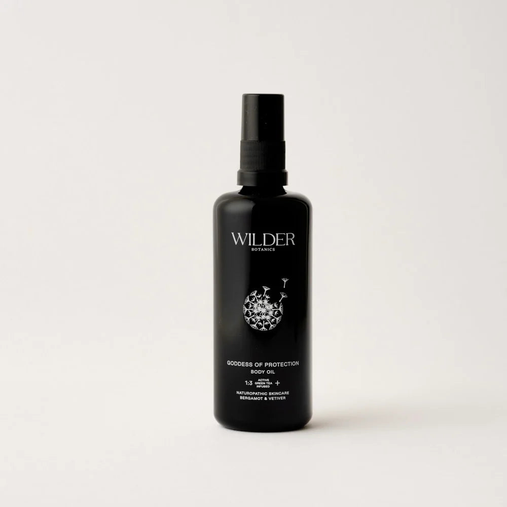The "Goddess of Protection Body Oil" by Wilder Botanics comes in a black bottle with a pump dispenser, enriched with Sea Buckthorn. It features botanical artwork on the label against a plain white background.